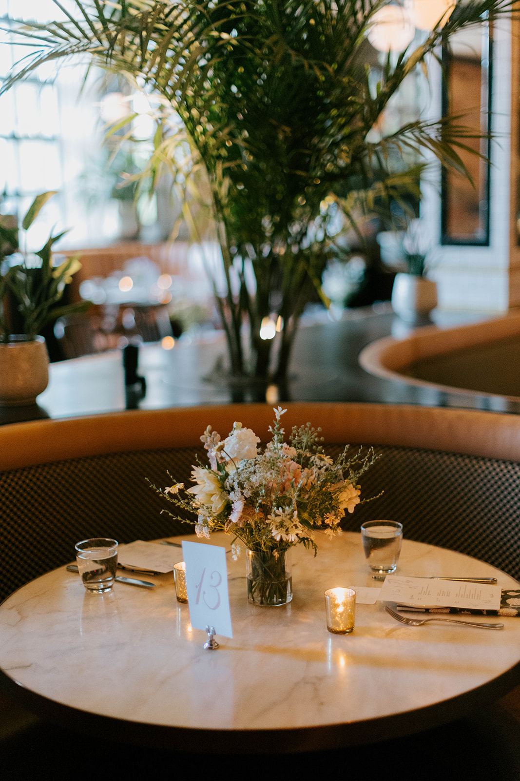 Round marble table with a low floral centrepiece and table number