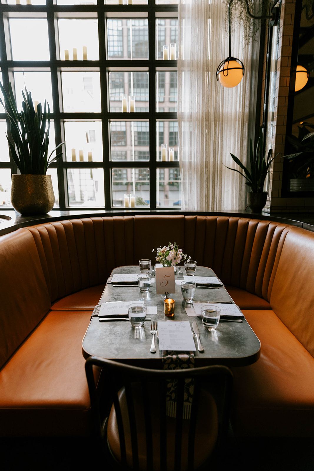 Leather banquette table set with a block-printed runner and menus