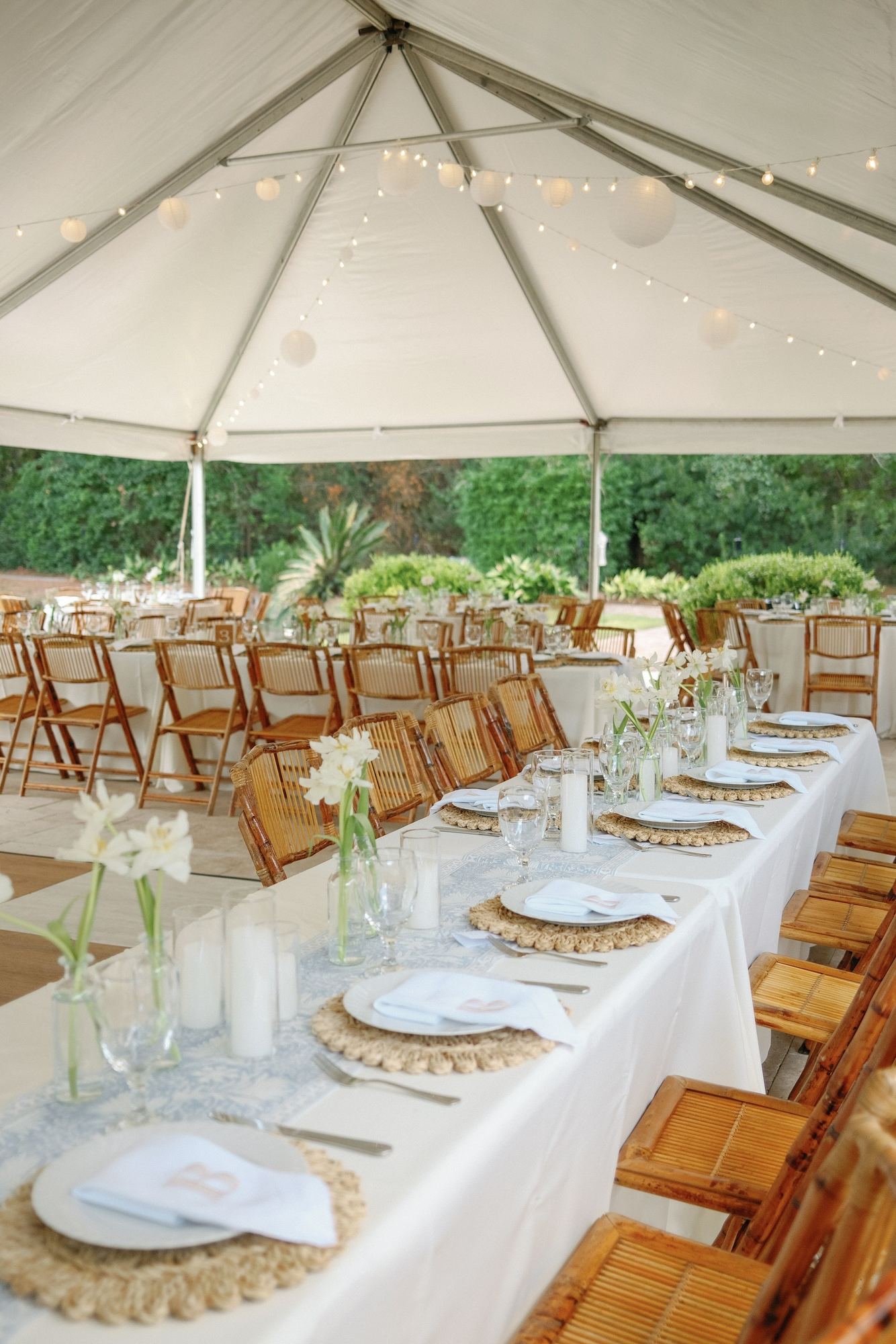 Long tented table with a Nila Blue runner, monogrammed napkins and woven chargers