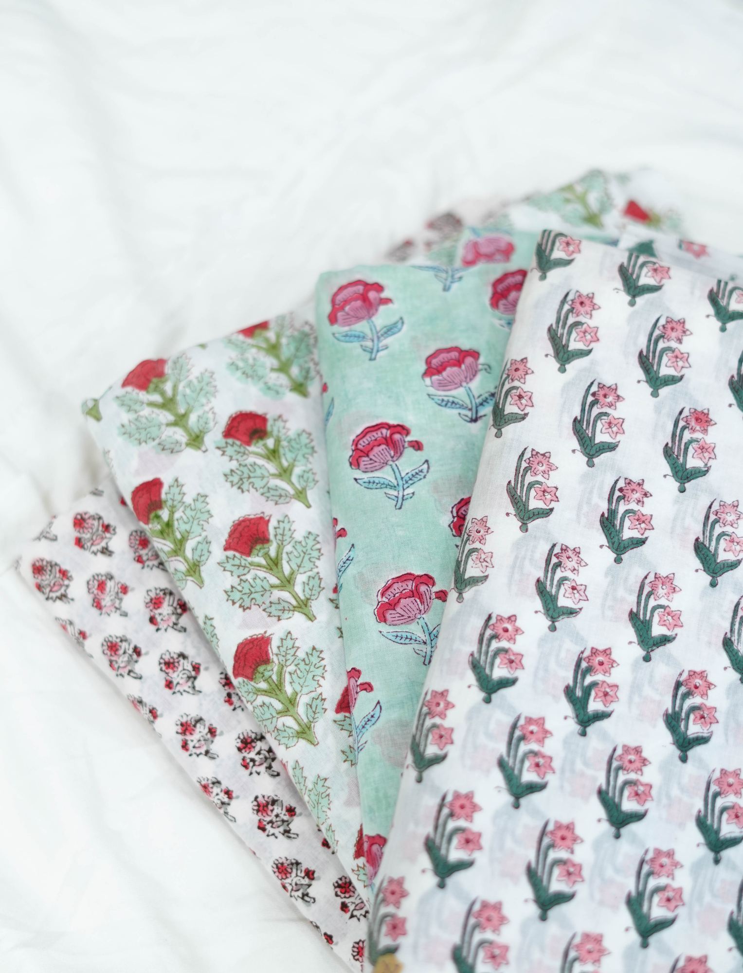 Folded block-printed cottons stacked in the studio