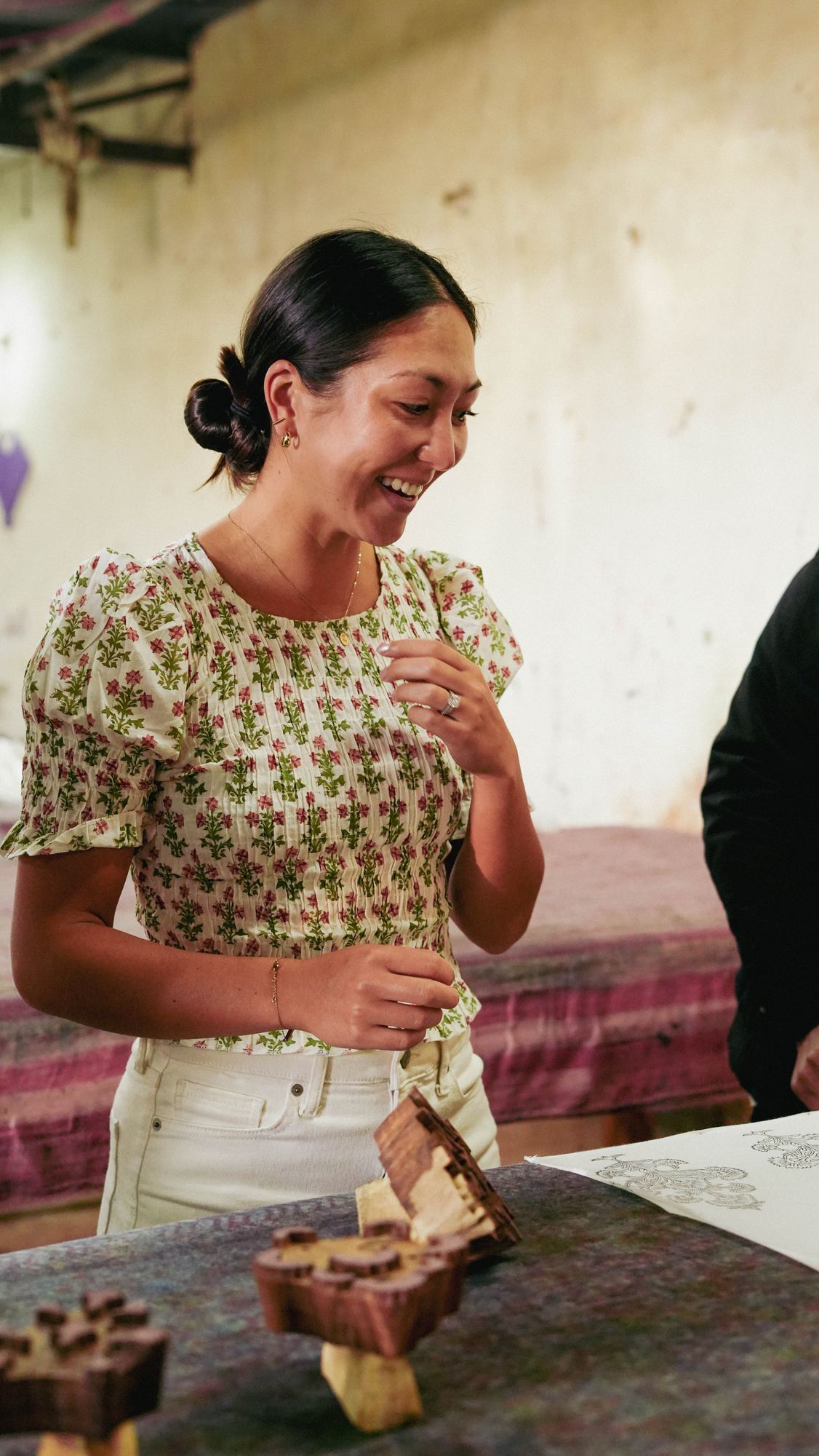 The founder of Loopy Leopard Linens at a block-printing table with hand-carved wooden blocks