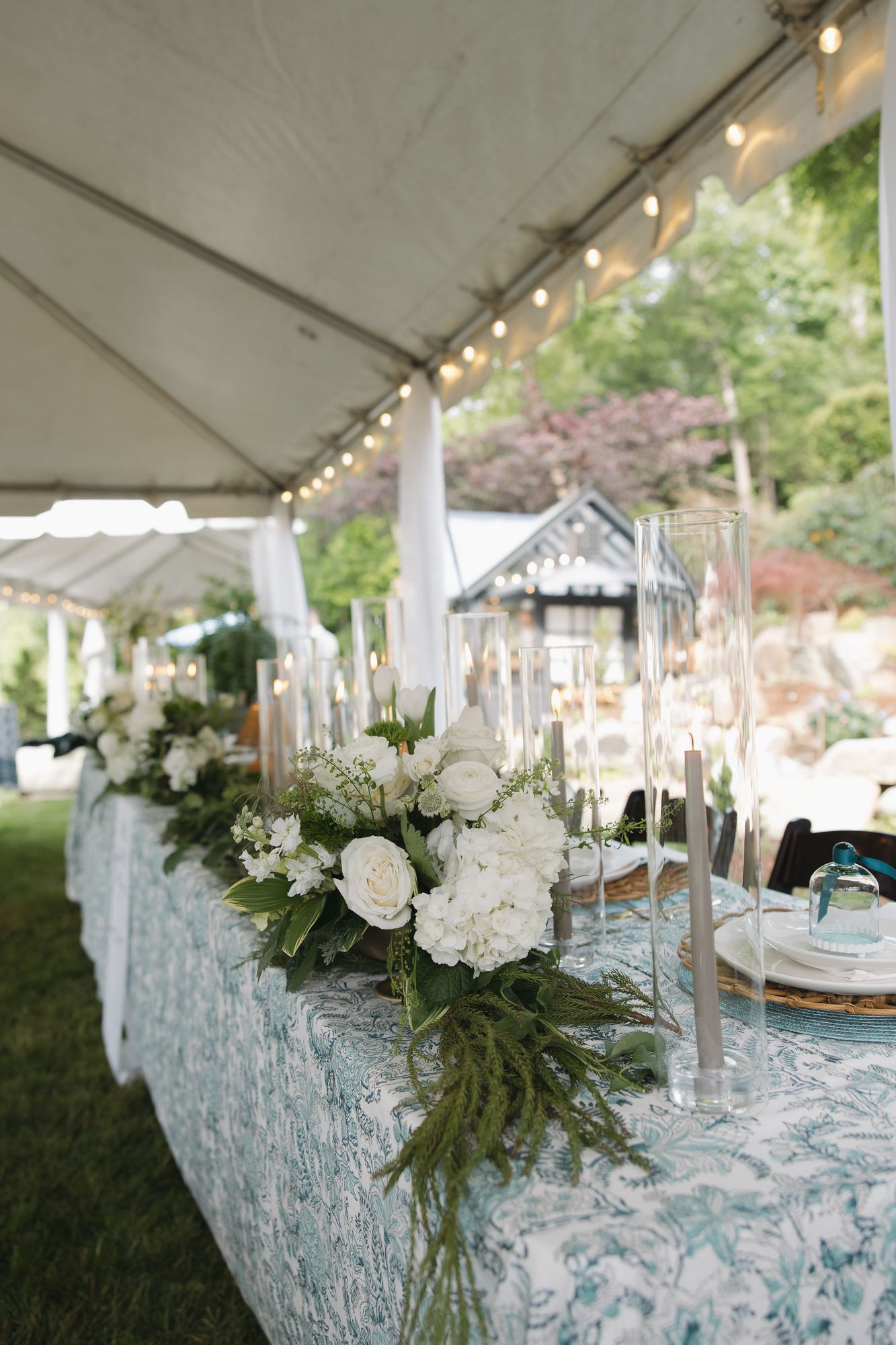 Head table in teal block print with white florals under a tent