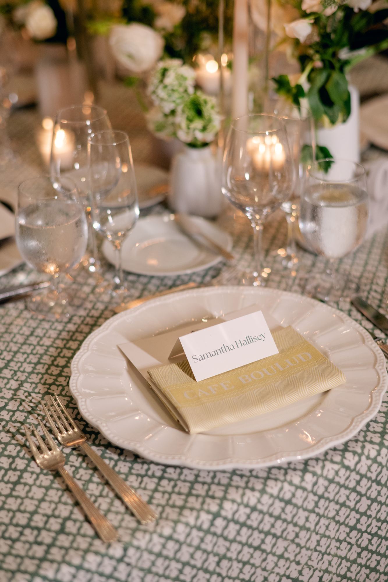Place setting with gold flatware on a green block-printed cloth