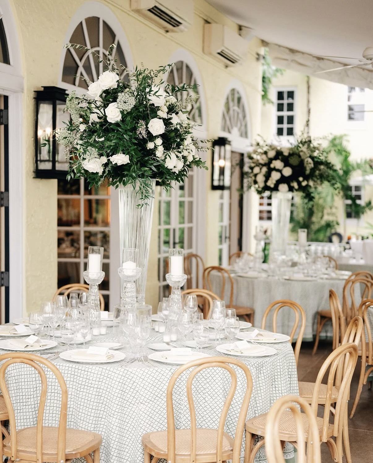 Palm Beach round tables in a green and white block print with tall white florals