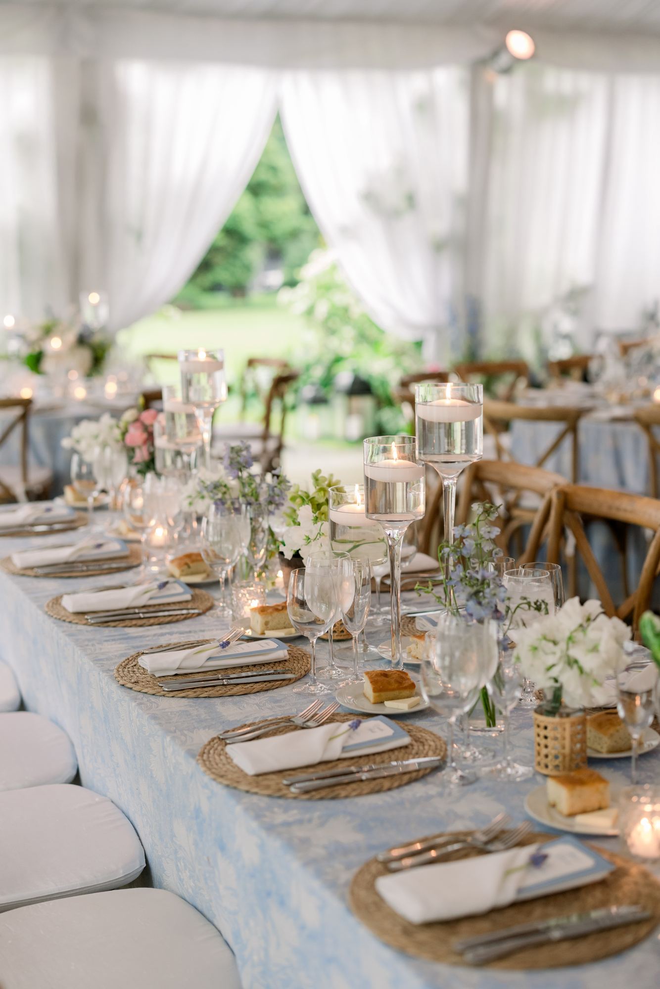 Long tented table under a pale blue floral block print with rope chargers