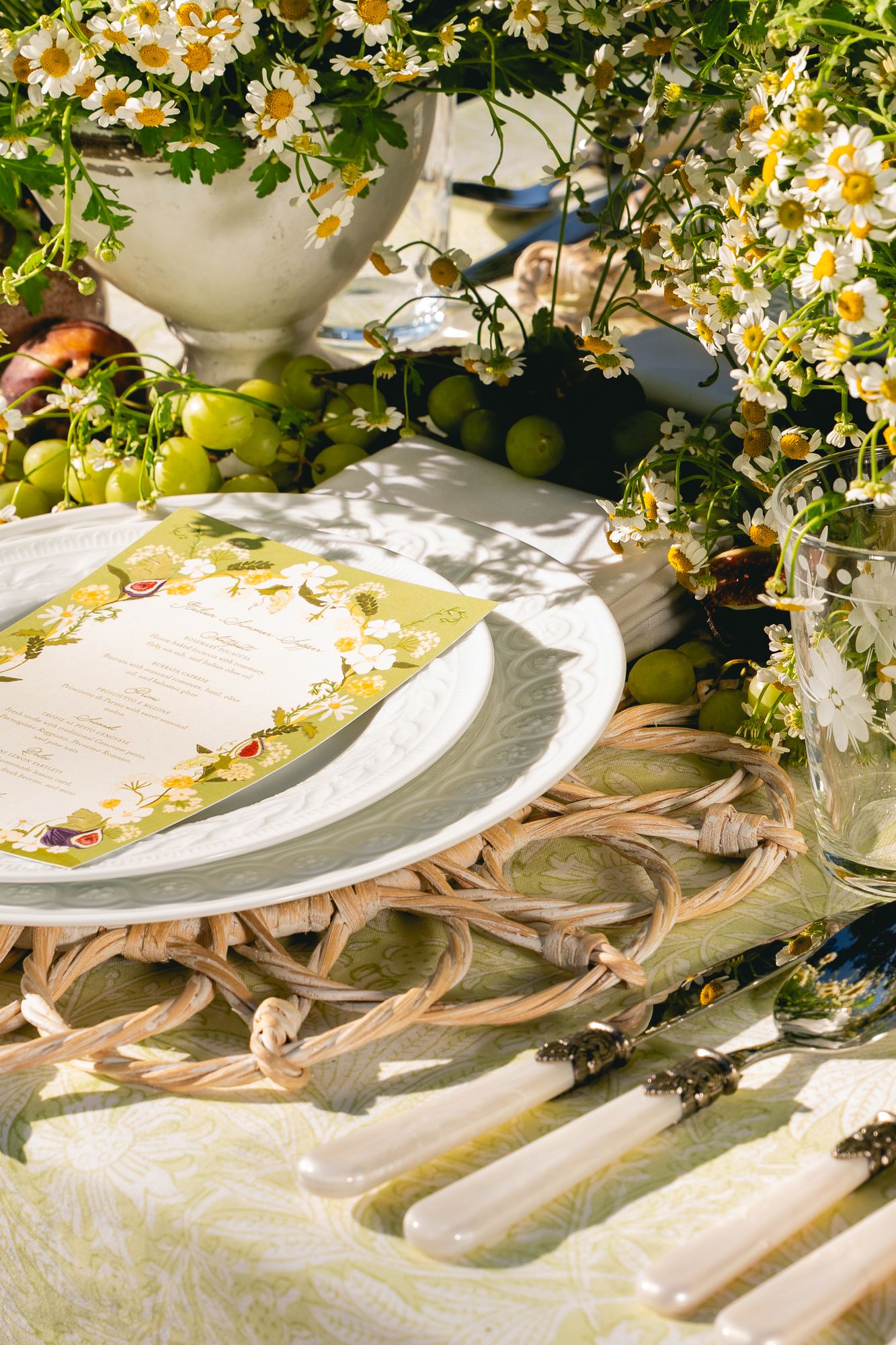 Menu card on stacked plates over a citron printed cloth