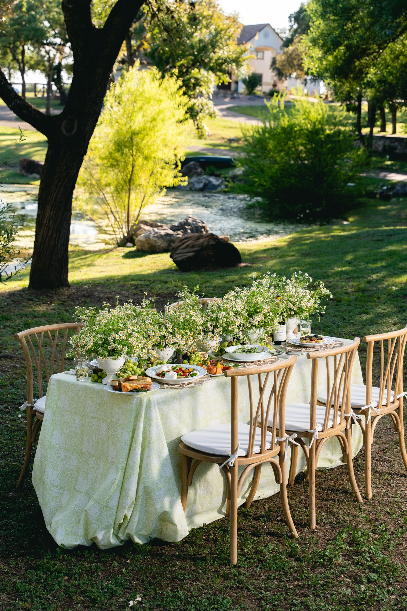 Table in citron block print set beside a creek under oak trees