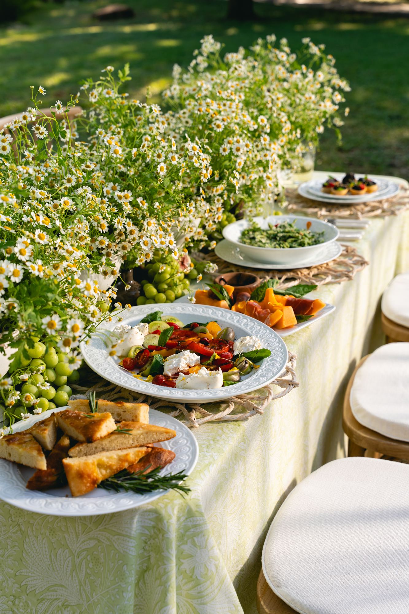 Citron floral block-printed cloth running the length of an outdoor table