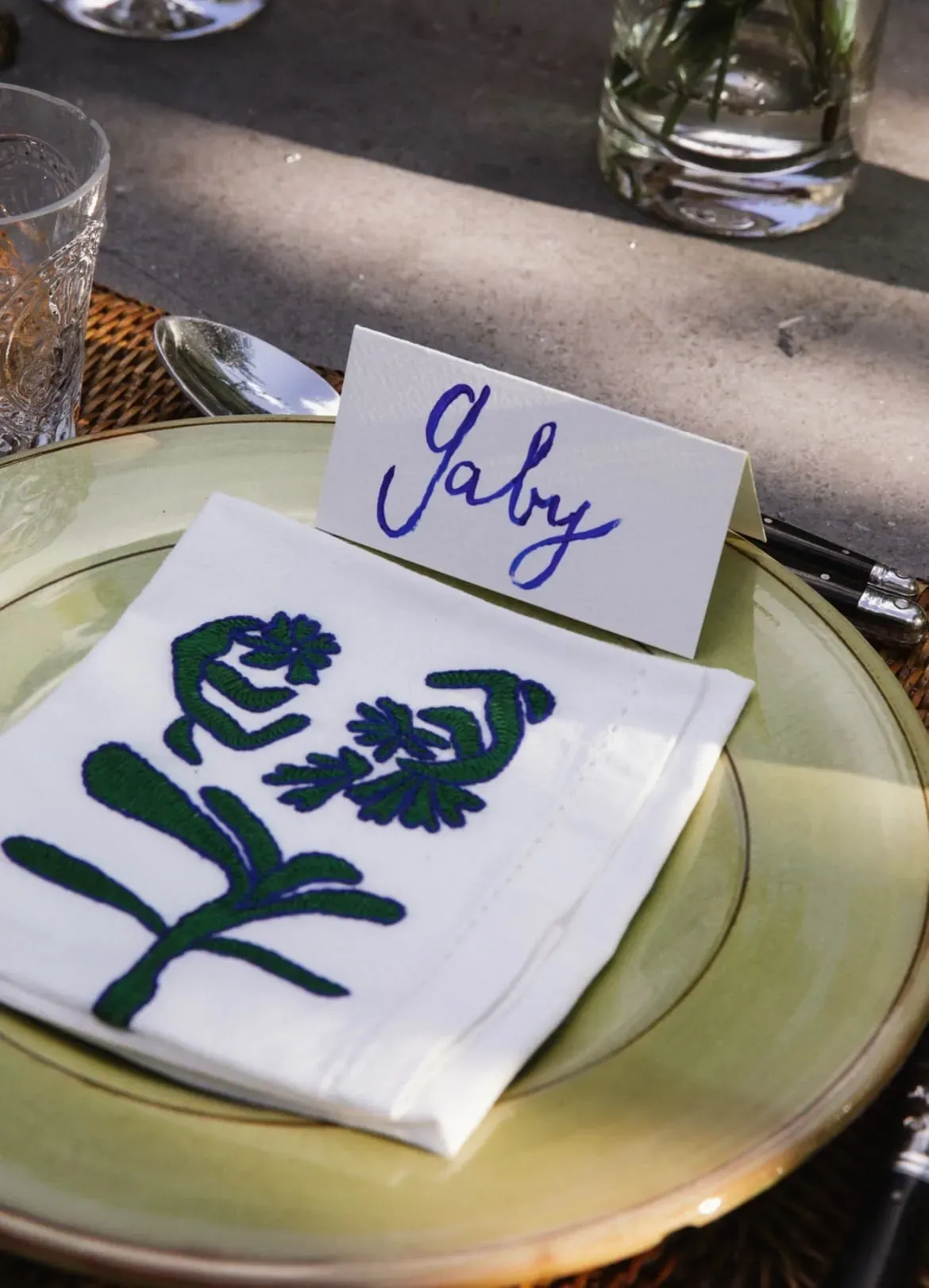 Hand-embroidered floral napkin on a celadon plate, the Netherlands
